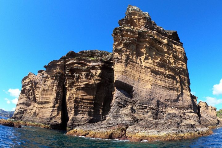 a rocky island in the middle of a body of water
